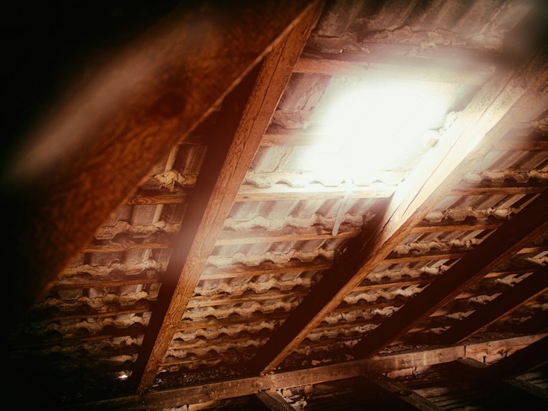 An attic interior with the rafters and decking visible