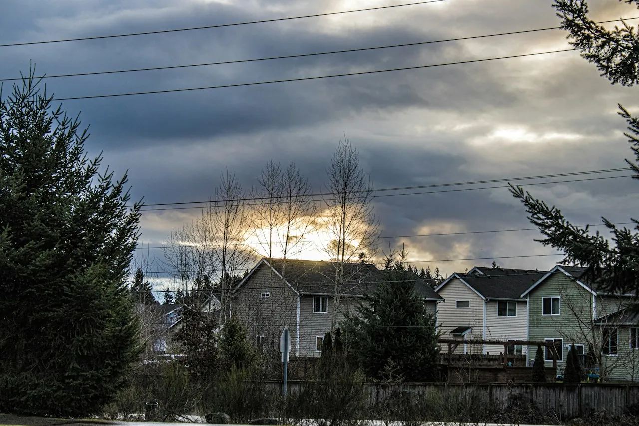 Storm clouds breaking over two-story houses on a suburban street